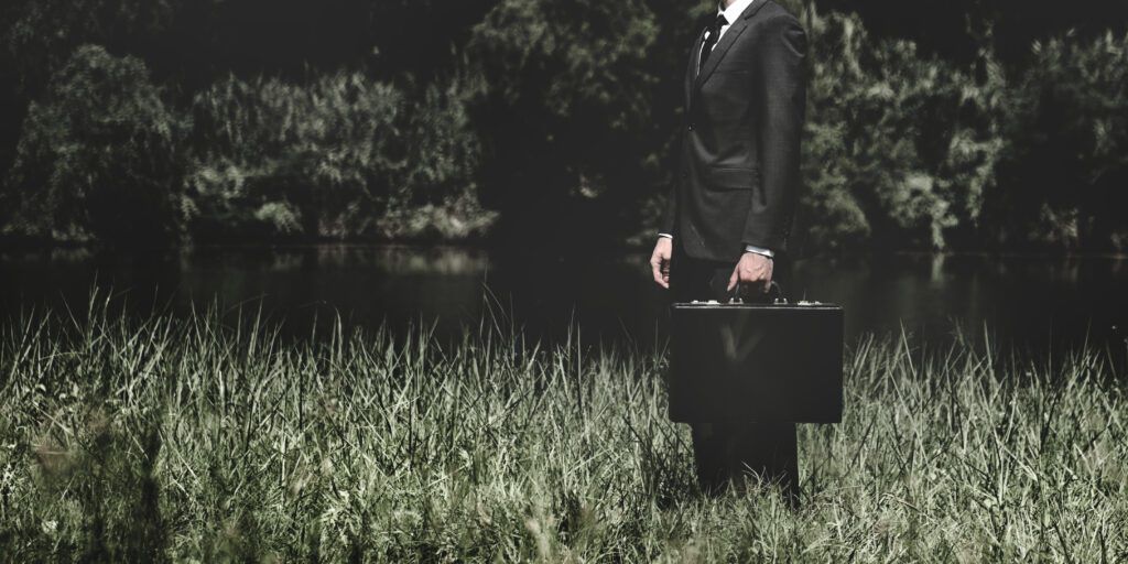 Somber Professional with dark suite and black briefcase life cover vs funeral cover - which one do you choose